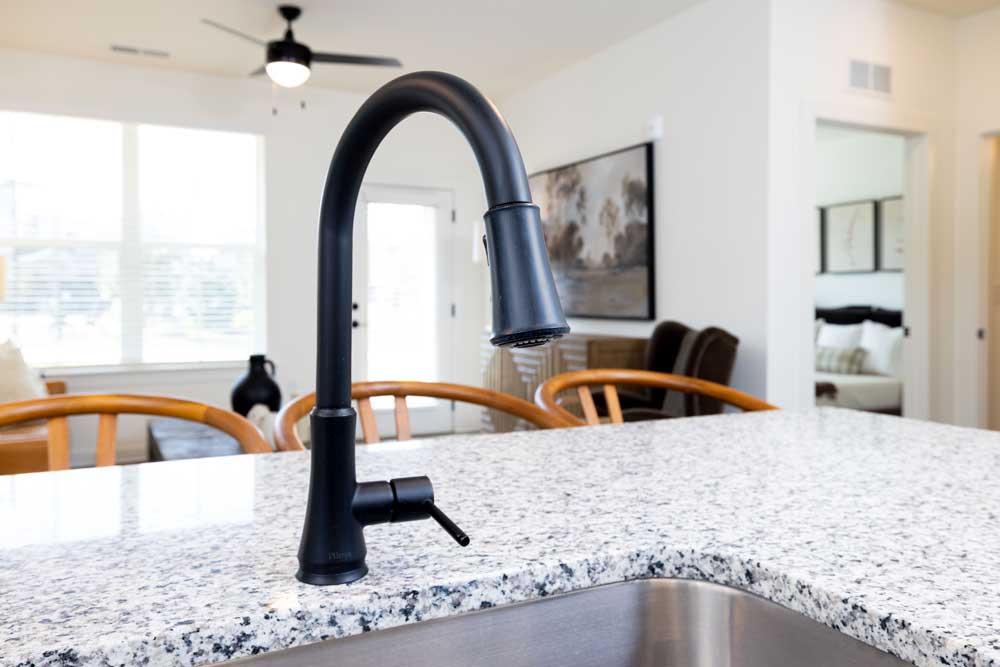 Kitchen counter with black faucet and granite countertop